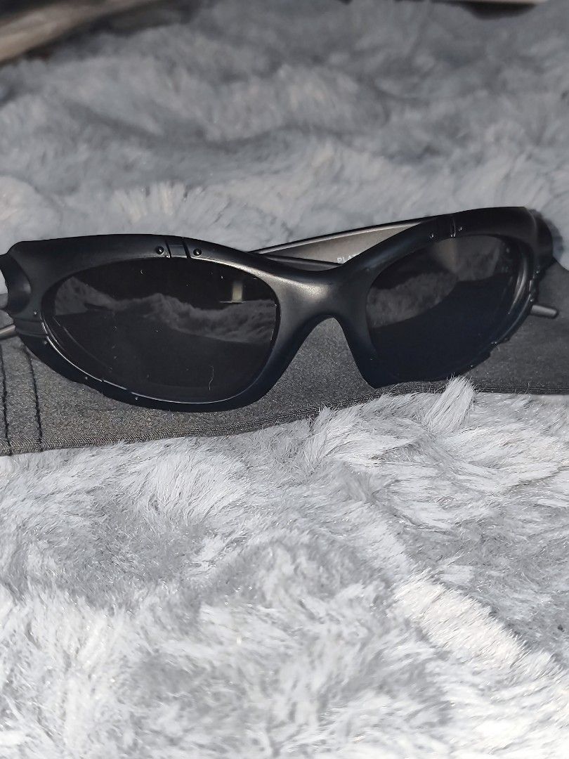 Oakley Sunglasses Matte Black (Category: Sunglasses & Eyewear) located in Manila. Submitted by crazylocc887246 (Listing ID 1465488057, Image 1). Description: - Brand: Oakley - Color: Matte black finish - Lenses: Dark tinted for glare reduction - Design: Aggressive sports styling with wrap-around frame - Details: Iconic side logo on temple arms - Condition/Inclusion: Comes with a protective cloth sleeve - Best for: Outdoor activities, riding, and 