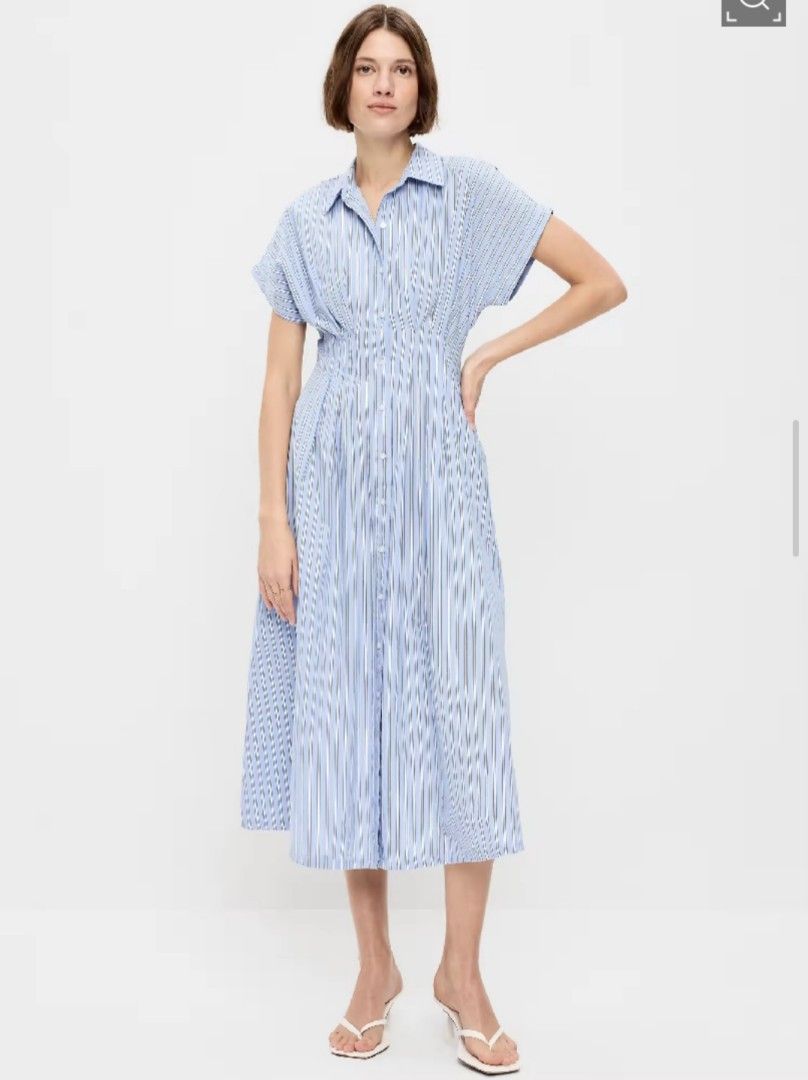 Old Navy Blue Striped Button Front Midi Dress (Category: Dresses) located in Valenzuela. Submitted by just_m33 (Listing ID 1465547889, Image 2). Description: - Brand: Old Navy - Design: Blue and white striped shirt dress with midi length and a slight front slit - Features: Short sleeves, pointed collar, button-down front, and fitted waist with gathered pleats - Material: Lightweight and comfortable - Versatility: Perfect for both workwear and cas