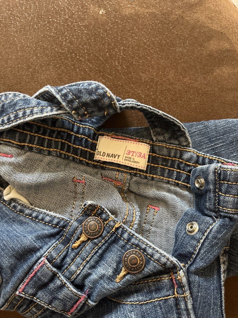 Old Navy Denim Overalls Size 3T (Category: Babies & Kids Fashion) located in Carmona. Submitted by abimeng08 (Listing ID 1465444207, Image 3). Description: Old Navy denim overalls for toddlers. Size 3T. Adjustable shoulder straps with metal buttons. Classic blue wash with pink contrast stitching accents. Front bib pocket, side pockets, and back pockets. Button closures on the sides. Made in Bangladesh..