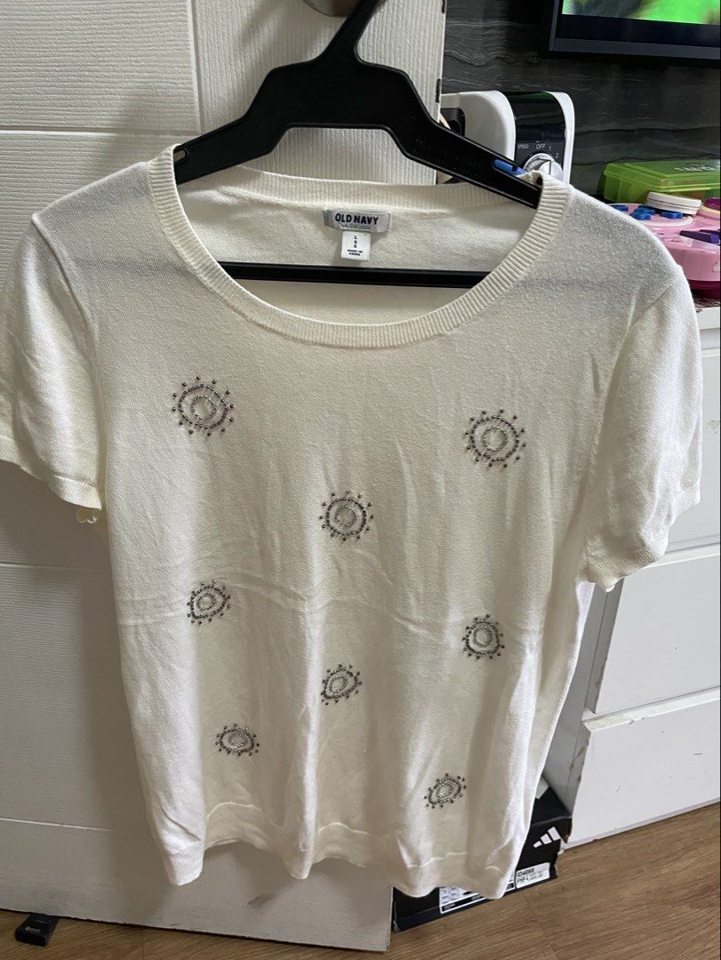 Old Navy White Beaded Short Sleeve Knit Top (Category: Blouses) located in Taguig. Submitted by declutteringmom314 (Listing ID 1465387035, Image 1). Description: - Brand: Old Navy - Size: Large - Color: Solid white with silver and bronze front bead details - Material: Lightweight knit sweater fabric - Design: Short sleeves, round ribbed neckline, and ribbed cuffs - Condition: Excellent pre-loved condition (ready to wear).