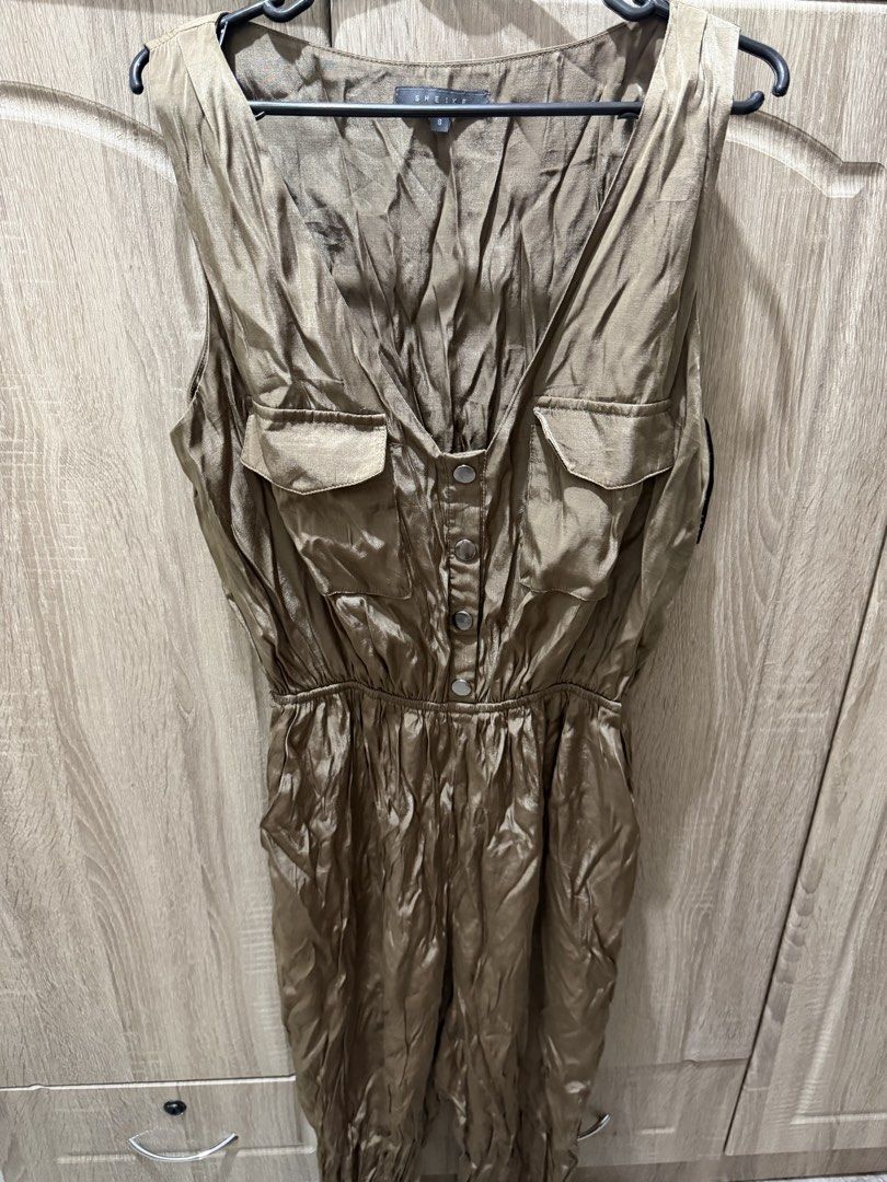 Olive Green Sleeveless Jumpsuit (Category: Jumpsuits) located in Calamba. Submitted by nicalison (Listing ID 1465456903, Image 2). Description: - Brand: Sheike - Size: 8 - Color: Olive Green - Material: Silky smooth finish - Design: Sleeveless, V-neck front with button placket, and elasticated waistband - Pockets: Two chest flap pockets and functional side pockets - Condition: Great pre-loved condition, needs a quick steam/iron before wearing.