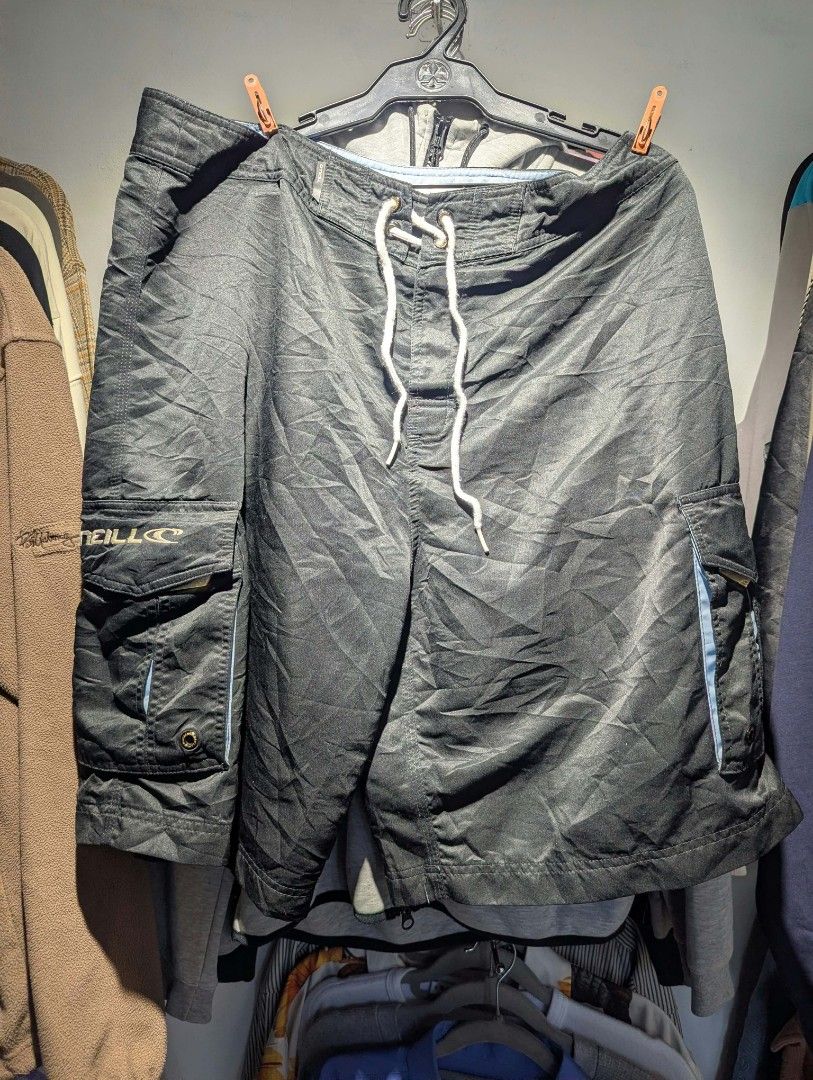 O'Neill Black Cargo Board Shorts with Drawstring (Category: Shorts) located in Manila. Submitted by grandwater.53a8ce (Listing ID 1465492651, Image 1). Description: - Brand: O'Neill - Color: Black with blue contrast piping - Waist: White adjustable drawstring with metal grommets - Pockets: Dual side cargo pockets (one features embroidered logo and wave graphic) - Details: O'Neill wave logo print near the back waistband; fabric has a slight sheen 