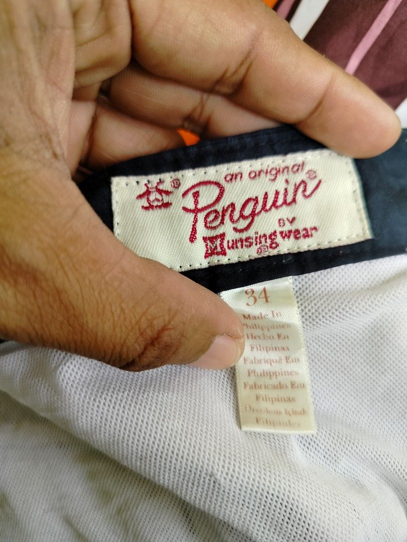 Original Penguin Striped Board Shorts Size 34 (Category: Swim Trunks & Board Shorts) located in Manila. Submitted by gerald_quinto (Listing ID 1465470598, Image 3). Description: - Brand: Original Penguin - Size: 34 - Design: Multi-color horizontal stripes (blue, maroon, orange, yellow, white) with a solid black waistband - Closure: Secure snap button closure - Pockets: Two convenient rear flap pockets - Details: Embroidered pink penguin logo near
