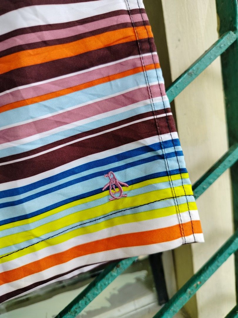 Original Penguin Striped Board Shorts Size 34 (Category: Swim Trunks & Board Shorts) located in Manila. Submitted by gerald_quinto (Listing ID 1465470598, Image 2). Description: - Brand: Original Penguin - Size: 34 - Design: Multi-color horizontal stripes (blue, maroon, orange, yellow, white) with a solid black waistband - Closure: Secure snap button closure - Pockets: Two convenient rear flap pockets - Details: Embroidered pink penguin logo near