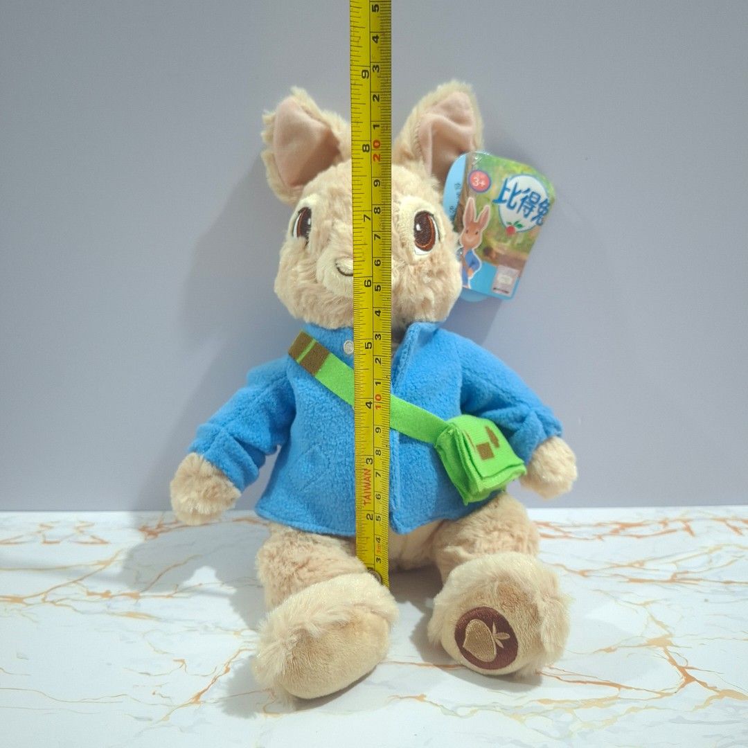 Peter Rabbit plush toy stuffed animal with blue jacket (Category: Plushies & Soft Toys) located in Baguio. Submitted by marjshane11317 (Listing ID 1465529237, Image 2). Description: - Authentic Peter Rabbit stuffed toy with official holographic tag - Features iconic blue jacket and green cross-body bag - Brand new, tag attached (never played with or displayed) - Measures approximately 20 cm long - Made with soft plush material and detailed embroi