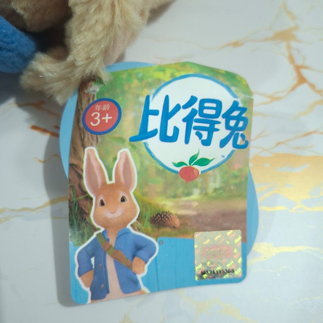 Peter Rabbit plush toy stuffed animal with blue jacket (Category: Plushies & Soft Toys) located in Baguio. Submitted by marjshane11317 (Listing ID 1465529237, Image 3). Description: - Authentic Peter Rabbit stuffed toy with official holographic tag - Features iconic blue jacket and green cross-body bag - Brand new, tag attached (never played with or displayed) - Measures approximately 20 cm long - Made with soft plush material and detailed embroi
