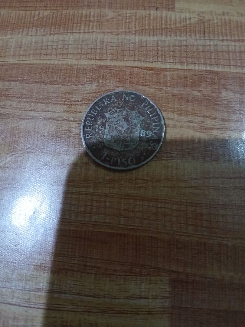 Philippine 1 Piso Coin 1989 (Category: Currency) located in Caloocan City. Submitted by vastdolphin.79423c (Listing ID 1465476680, Image 1). Description: - Item: 1989 Philippine 1 Piso Coin - Commemorative: Dekada ng Kulturang Pilipino (1988-1998) - Obverse: Republica ng Pilipinas design - Condition: Heavily circulated with visible wear, tarnish, and scratches - Details: Lettering and raised designs remain clear and legible.