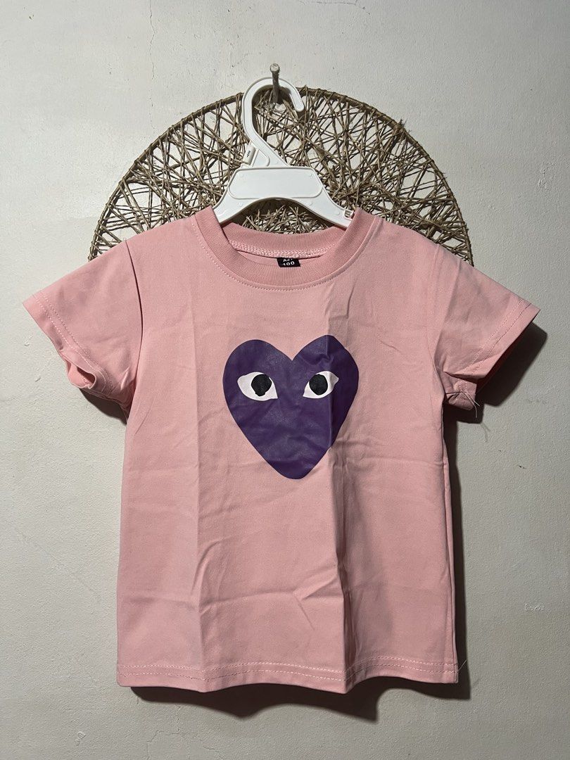 Pink Kids T-Shirt (Category: Babies & Kids Fashion) located in Pasig City. Submitted by ilmsf (Listing ID 1465509633, Image 1). Description: - Adorable pink short sleeve t-shirt for kids - Features a large purple heart graphic with quirky black and white eyes - Comfortable ribbed crew neck collar - Tag size: 100 ( 4-5yrs old ) - Made from soft, breathable cotton material - Perfect for everyday casual outfits.