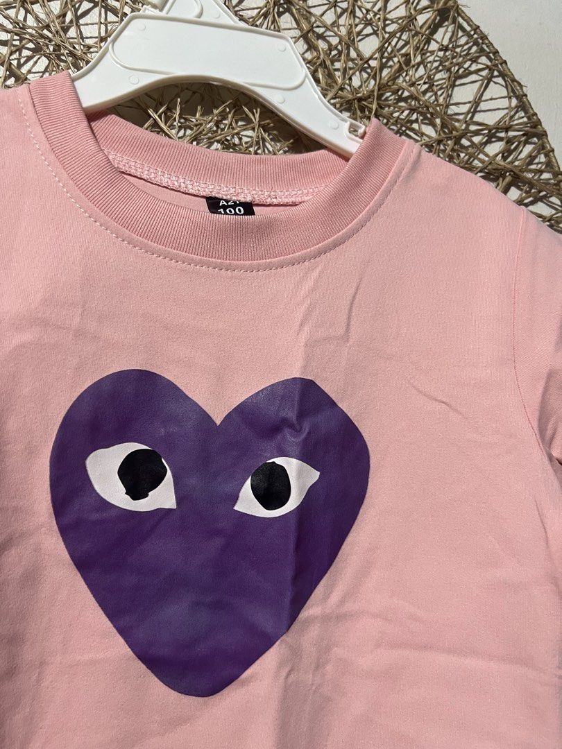 Pink Kids T-Shirt (Category: Babies & Kids Fashion) located in Pasig City. Submitted by ilmsf (Listing ID 1465509633, Image 2). Description: - Adorable pink short sleeve t-shirt for kids - Features a large purple heart graphic with quirky black and white eyes - Comfortable ribbed crew neck collar - Tag size: 100 ( 4-5yrs old ) - Made from soft, breathable cotton material - Perfect for everyday casual outfits.