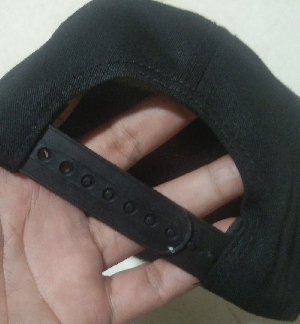 Plain Black Snapback Cap (Category: Caps & Hats) located in Quezon City. Submitted by aljonbermu25659 (Listing ID 1465395212, Image 3). Description: - Color: Solid black - Brim: Flat style - Fit: Adjustable plastic strap at the back - Construction: Structured crown panels with clean stitching - Details: Inner tag with QR code near the closure - Style: Minimalist and versatile for everyday wear.
