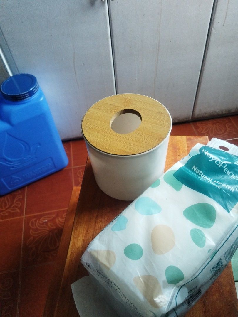 Plastic Tissue Holder with Wooden Lid (Category: Bathroom & Kitchen Fixtures) located in Caloocan City. Submitted by freerabbit.2292f7 (Listing ID 1465409380, Image 1). Description: White plaatic tissue container paired with a wooden bamboo-style lid. Central hole dispenses tissues smoothly..