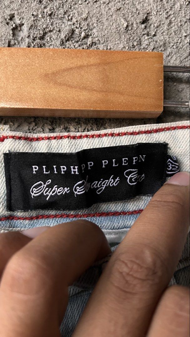 PLIPHPP PLEPN Super Straight Cut Distressed Denim Jeans (Category: Jeans) located in Cabuyao City. Submitted by bulandos (Listing ID 1465471247, Image 3). Description: - Size: 32 Waist - Fit: Super straight cut - Wash/Color: Light wash with faded treatment and heavy texture - Details: Heavy distressing, edgy rips, and unique patchwork - Hardware & Branding: Custom skull buttons and branded leather back patch - Condition: Brand new with original t