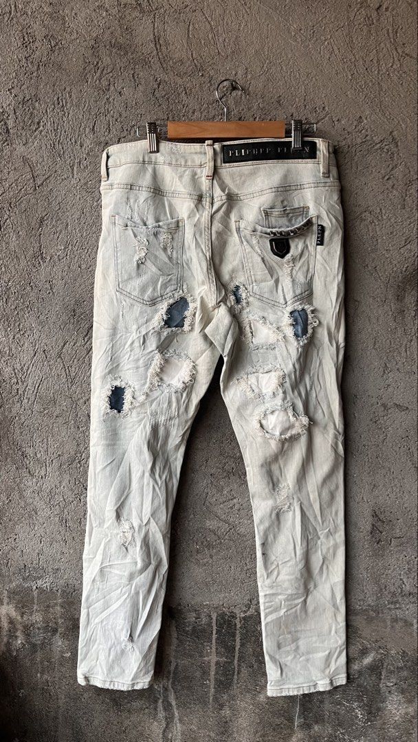 PLIPHPP PLEPN Super Straight Cut Distressed Denim Jeans (Category: Jeans) located in Cabuyao City. Submitted by bulandos (Listing ID 1465471247, Image 2). Description: - Size: 32 Waist - Fit: Super straight cut - Wash/Color: Light wash with faded treatment and heavy texture - Details: Heavy distressing, edgy rips, and unique patchwork - Hardware & Branding: Custom skull buttons and branded leather back patch - Condition: Brand new with original t