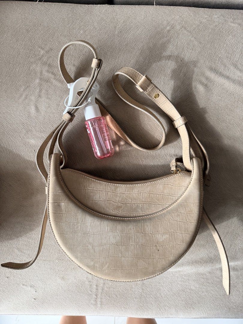 Polène Numéro Dix Suede Crocodile Embossed Bag (Category: Luxury Bags & Wallets) located in Quezon City. Submitted by hjane26 (Listing ID 1465503074, Image 2). Description: - Brand: Polène - Style: Crescent-shaped crossbody bag - Material: Beige embossed suede leather with gold-tone hardware - Closure: Top zip closure with front flap debossed logo - Strap: Adjustable crossbody strap. Comes with a shoulder strap. - Condition: Noticeable discolorat