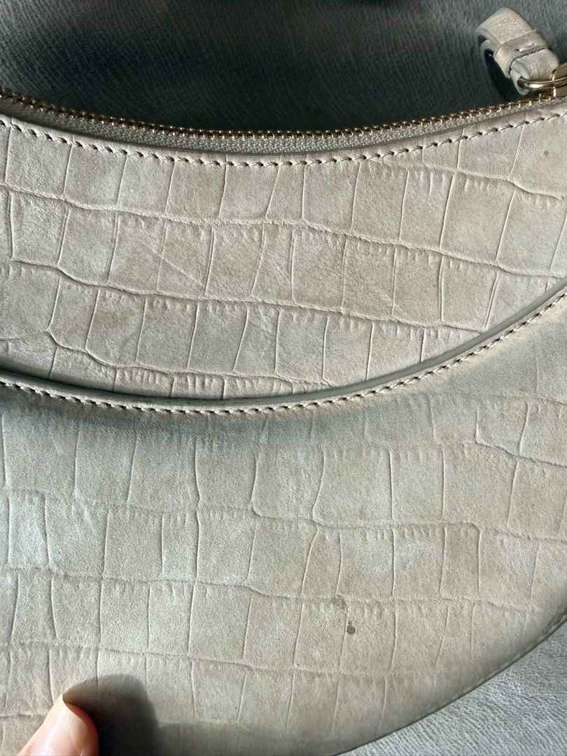 Polène Numéro Dix Suede Crocodile Embossed Bag (Category: Luxury Bags & Wallets) located in Quezon City. Submitted by hjane26 (Listing ID 1465503074, Image 3). Description: - Brand: Polène - Style: Crescent-shaped crossbody bag - Material: Beige embossed suede leather with gold-tone hardware - Closure: Top zip closure with front flap debossed logo - Strap: Adjustable crossbody strap. Comes with a shoulder strap. - Condition: Noticeable discolorat