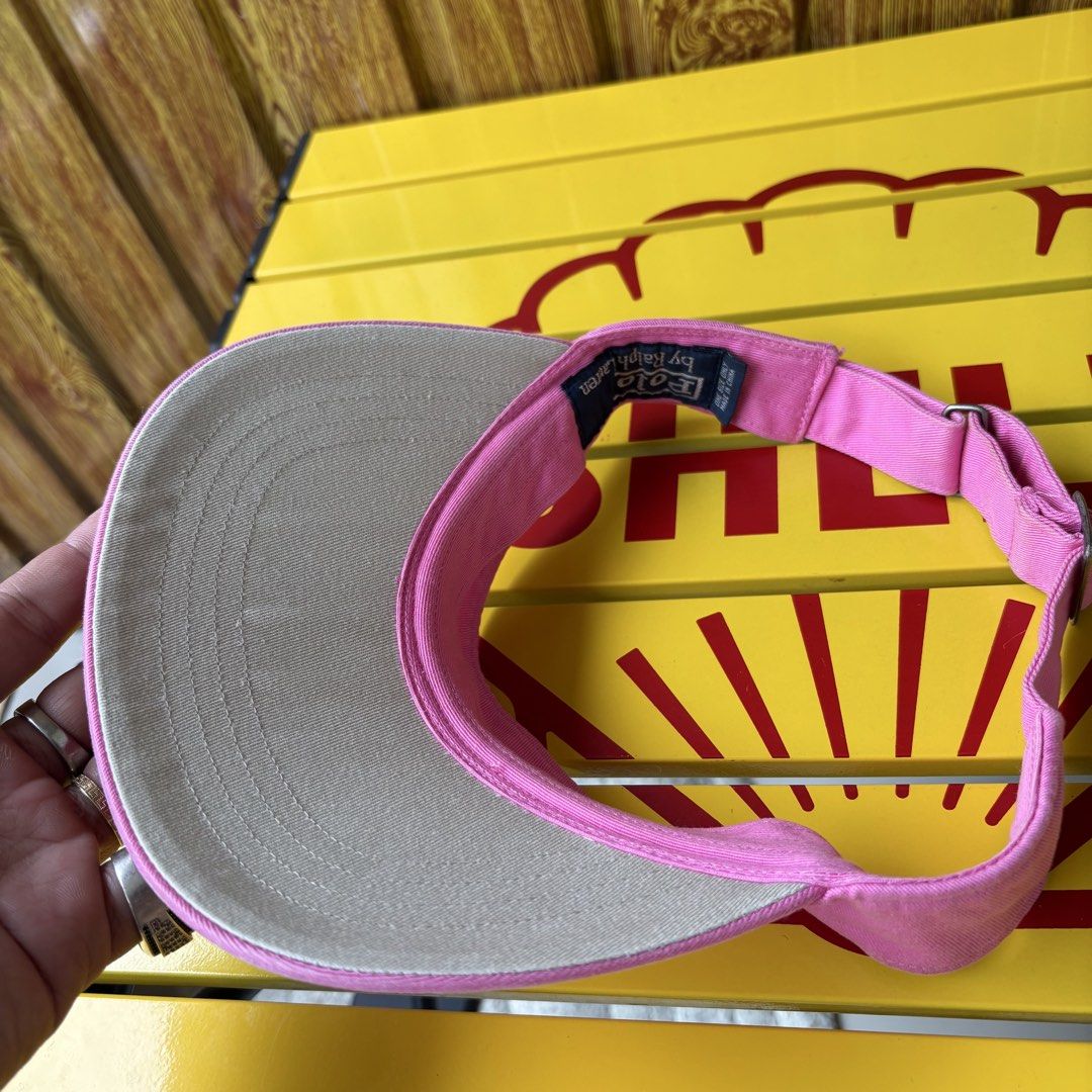 Polo Ralph Lauren Pink Sun Visor (Category: Hats & Beanies) located in Dapitan. Submitted by payt3es_thrift. (Listing ID 1465392322, Image 3). Description: - Brand: Polo Ralph Lauren - Color: Bright pink with classic blue embroidered pony - Fit: Adjustable metal strap in the back, one size fits most - Details: Navy interior label, made in China - Condition: Great shade for sunny days out!.