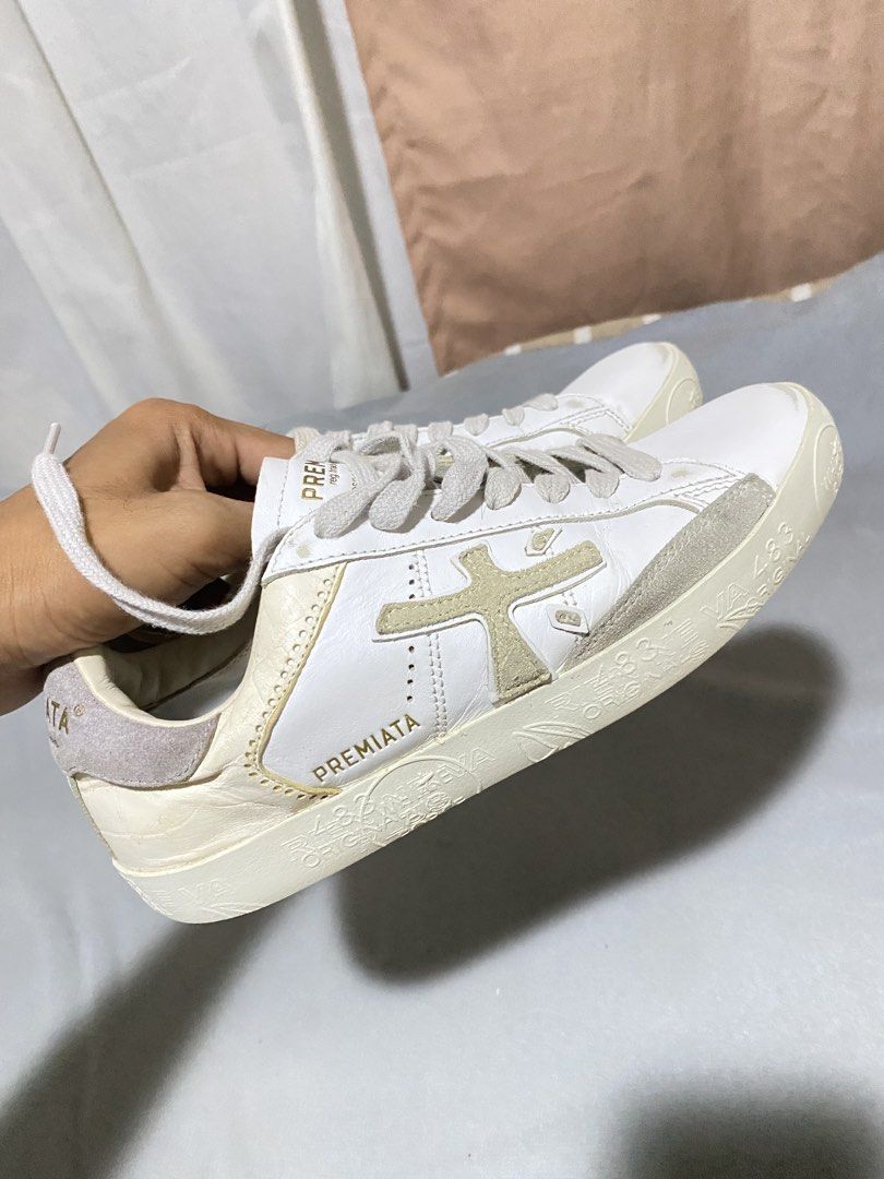 Premiata White Bespoke Trainer Sneakers (Category: Sneakers) located in Barobo. Submitted by sonogonggr22560 (Listing ID 1465502024, Image 1). Description: - issue: replace sole pad - Brand: Premiata Bespoke - Color: White with light grey and gold accents - Material: Premium textured leather upper with suede heel counter - Features: Distinctive side cross logo, gold branding on heel, and unique printed textured midsole - Closure: Classic lace-up 