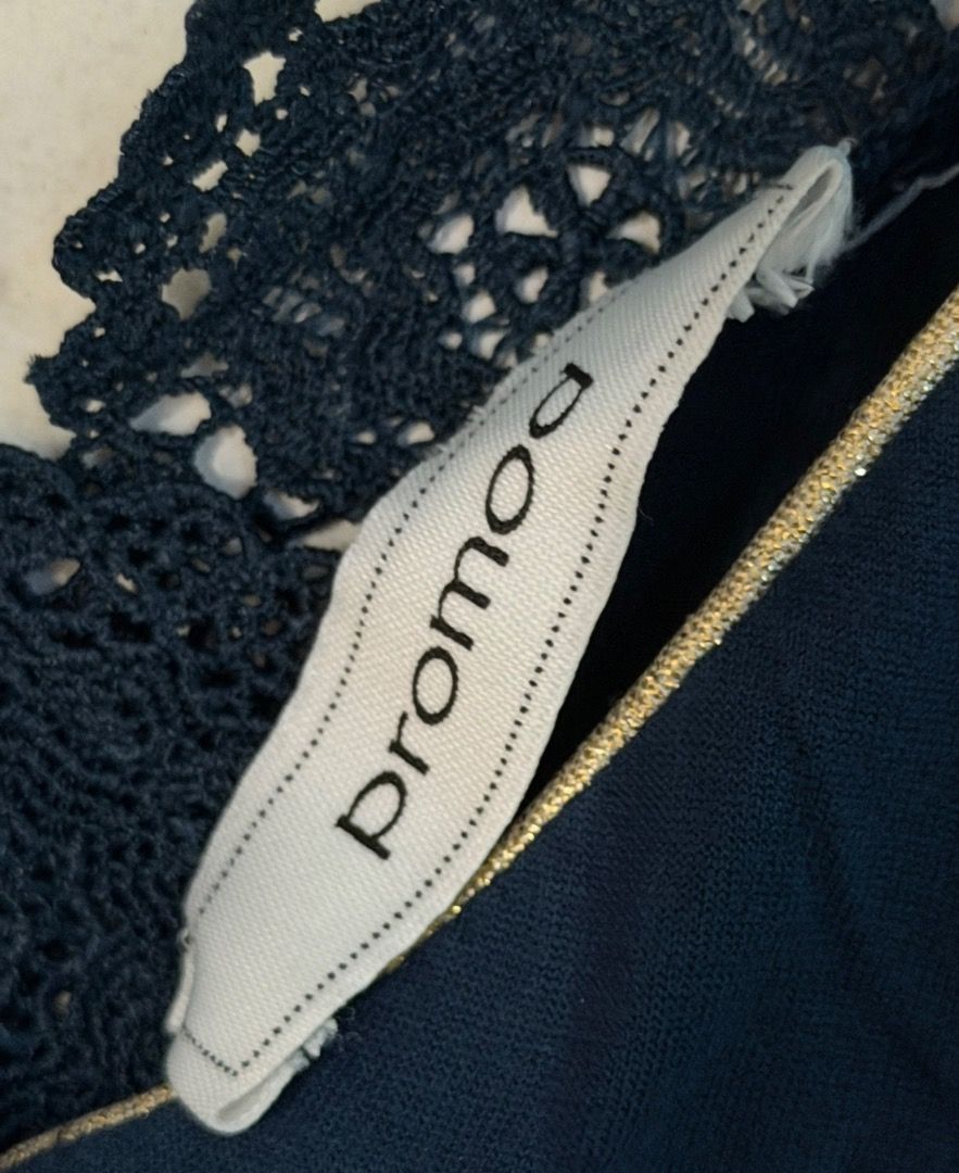 Dark Blue Blouse / Top from Promod (Category: Blouses) located in Santa Rosa. Submitted by biancamarie0404 (Listing ID 1465436242, Image 2). Description: - Brand: Promod - Color: Dark blue - Neckline: V-neck with metallic gold trim - Back Details: Deep V-shape with dark lace panels and a horizontal top strap - Fit: Relaxed and soft - Style: Versatile for casual or dressed-up outfits.