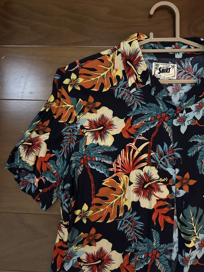 Pull&Bear Tropical Floral Resort Shirt Size L (Category: Shirts) located in Marikina City. Submitted by blk1012_ (Listing ID 1465569042, Image 2). Description: - Brand: Pull&Bear - Style: Tropical resort shirt / Camp collar - Color: Dark navy blue with vibrant floral and palm tree print - Size: EUR/USA L (MEX 40) - fits true to size - Material/Origin: Made in India - Condition: Great casual piece for summer or beach trips.