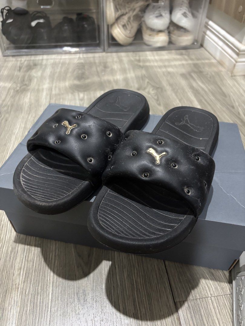 Puma Black Quilted Slides with Gold Logo (Category: Flats & Sandals) located in San Pablo. Submitted by loved.goods0501 (Listing ID 1465509752, Image 2). Description: Brand: Puma Size: EUR 38/ 25cm/US 8.5 Style: Slip-on slides with trendy puffy, quilted strap design Color: Black with eye-catching gold metallic Puma cat logo Comfort & Fit: Textured footbed for added grip and daily comfort Versatility: Great for casual wear, running errands, or poo