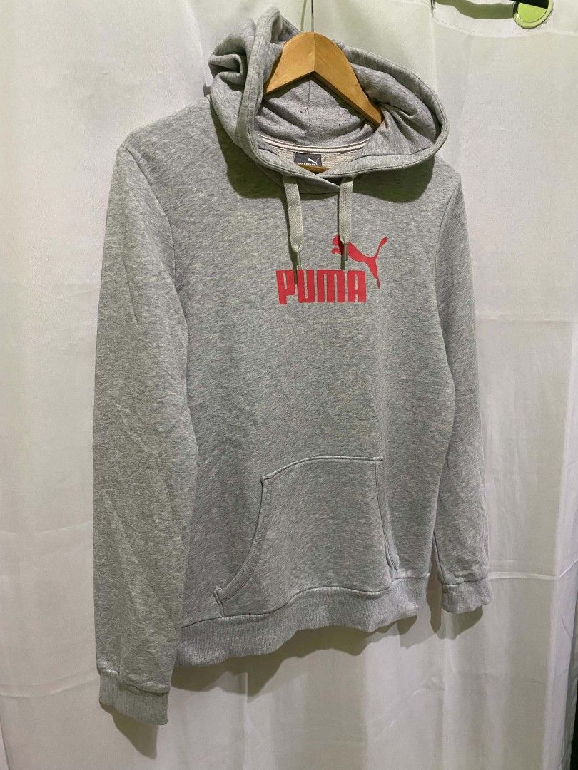 Puma Gray Hoodie Sweatshirt (Category: Hoodies) located in Quezon City. Submitted by elihur.tuazon (Listing ID 1465480186, Image 2). Description: - Color: Gray with a large pink Puma logo on the chest - Style: Pullover hoodie with drawstring and front kangaroo pocket - Interior: Soft fleece lining for extra warmth and comfort - Size: Labeled XL on the neck tag (Note: wash tag features Nike branding) - Condition: Great for casual, everyday wear.