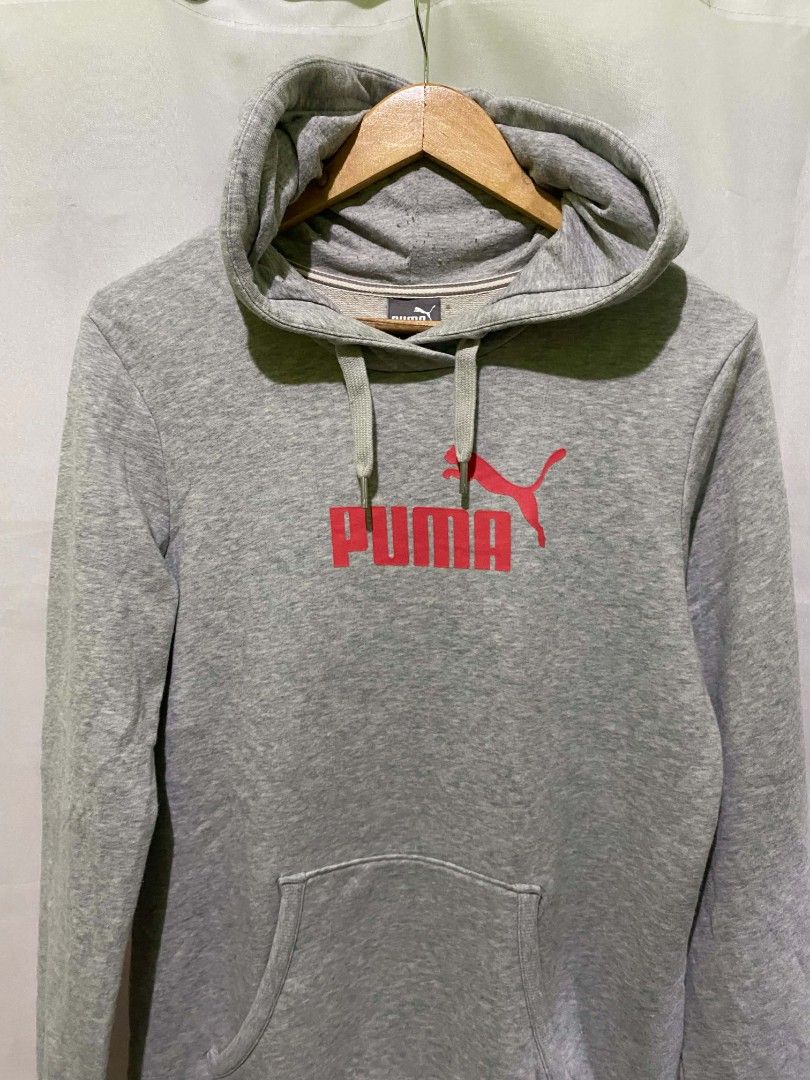Puma Gray Hoodie Sweatshirt (Category: Hoodies) located in Quezon City. Submitted by elihur.tuazon (Listing ID 1465480186, Image 1). Description: - Color: Gray with a large pink Puma logo on the chest - Style: Pullover hoodie with drawstring and front kangaroo pocket - Interior: Soft fleece lining for extra warmth and comfort - Size: Labeled XL on the neck tag (Note: wash tag features Nike branding) - Condition: Great for casual, everyday wear.