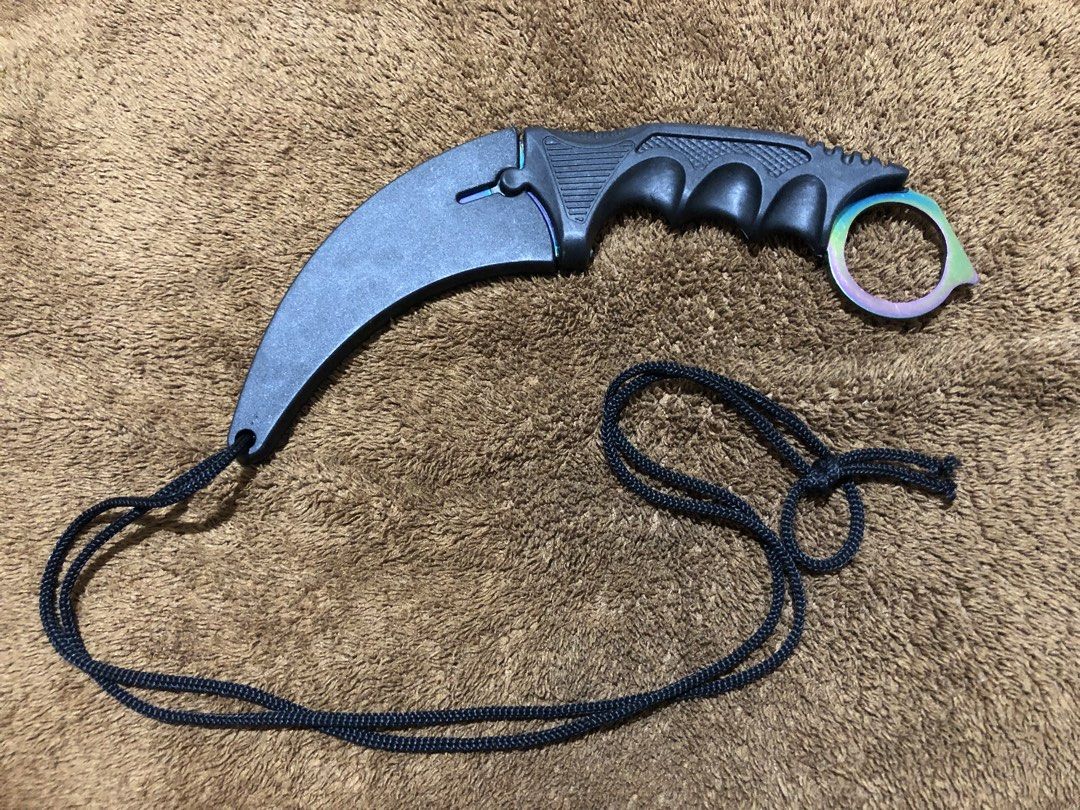 Rainbow Karambit with Sheath and Lanyard (Category: Knives & Chopping Boards) located in Bulacan. Submitted by crayation (Listing ID 1465466677, Image 1). Description: - Total Length: ~7 inches (measured with metal ruler) - Blade: Sharp rainbow gradient curved blade - Handle: Black textured grip with finger ring for security - Includes: Black plastic sheath and attached lanyard cord - Condition: Freshly sharpened, only minor scratches. - Good for