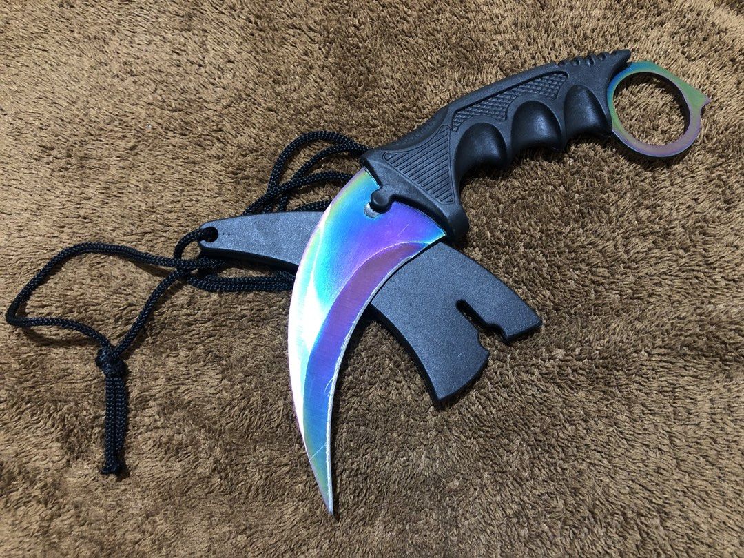 Rainbow Karambit with Sheath and Lanyard (Category: Knives & Chopping Boards) located in Bulacan. Submitted by crayation (Listing ID 1465466677, Image 2). Description: - Total Length: ~7 inches (measured with metal ruler) - Blade: Sharp rainbow gradient curved blade - Handle: Black textured grip with finger ring for security - Includes: Black plastic sheath and attached lanyard cord - Condition: Freshly sharpened, only minor scratches. - Good for