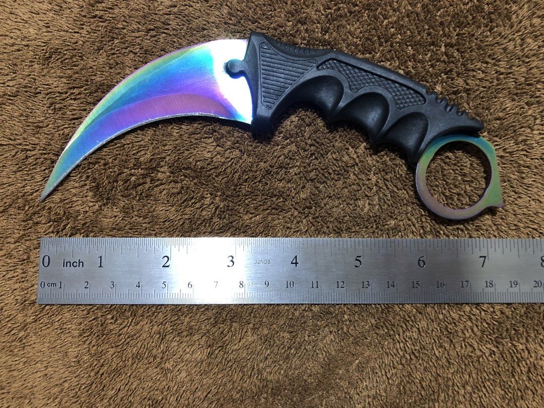 Rainbow Karambit with Sheath and Lanyard (Category: Knives & Chopping Boards) located in Bulacan. Submitted by crayation (Listing ID 1465466677, Image 3). Description: - Total Length: ~7 inches (measured with metal ruler) - Blade: Sharp rainbow gradient curved blade - Handle: Black textured grip with finger ring for security - Includes: Black plastic sheath and attached lanyard cord - Condition: Freshly sharpened, only minor scratches. - Good for