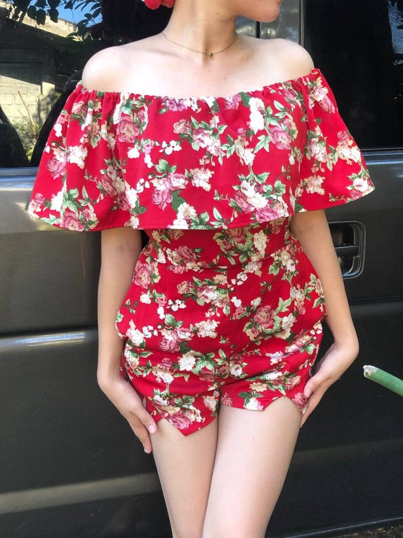 Red Floral Off-Shoulder Romper (Category: Rompers) located in Manila. Submitted by vintagefindssay (Listing ID 1465526913, Image 1). Description: - Bright red romper with pink and white roses - Off-shoulder neckline with a chic ruffled overlay - Functional deep pockets on both sides - Flattering high-waisted fit with built-in shorts - Lightweight, breathable fabric ideal for warm weather - Condition: Worn only once for a quick photo shoot, no fla
