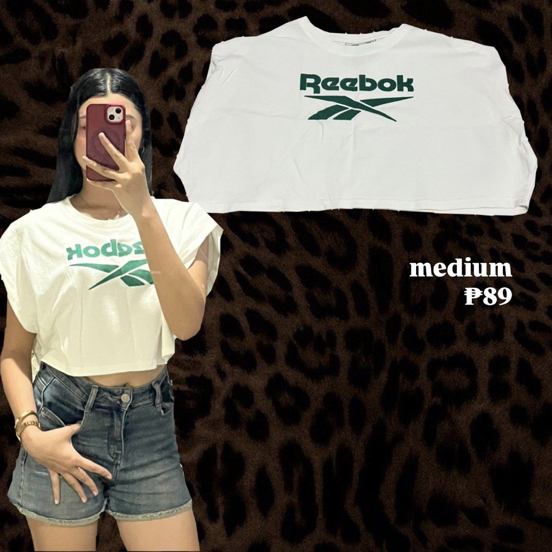 Reebok White Crop Top Medium (Category: Shirts) located in Tabaco. Submitted by kaisha_ (Listing ID 1465435728, Image 1). Description: - Brand: Reebok - Style: White crop top with green branding, short boxy sleeves, and raw hem - Size: Fits Medium comfortably - Condition: Great pre-loved condition - Perfect for: Casual days paired with high-waisted jeans or shorts.