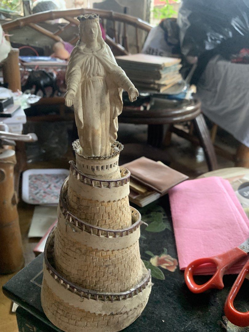 Religious Statue Figurine Mary Tower (Category: Religious Items) located in Quezon City. Submitted by sojisup (Listing ID 1465489825, Image 3). Description: - Elegant statue of Mary standing on a detailed spiral stone tower - Cream and beige color scheme with textured stonework and ramp railings - Features intricate details including a crown and flowing robes - Compact size, ideal for desk or shelf collections - Note: Minor dust and dirt in crevi