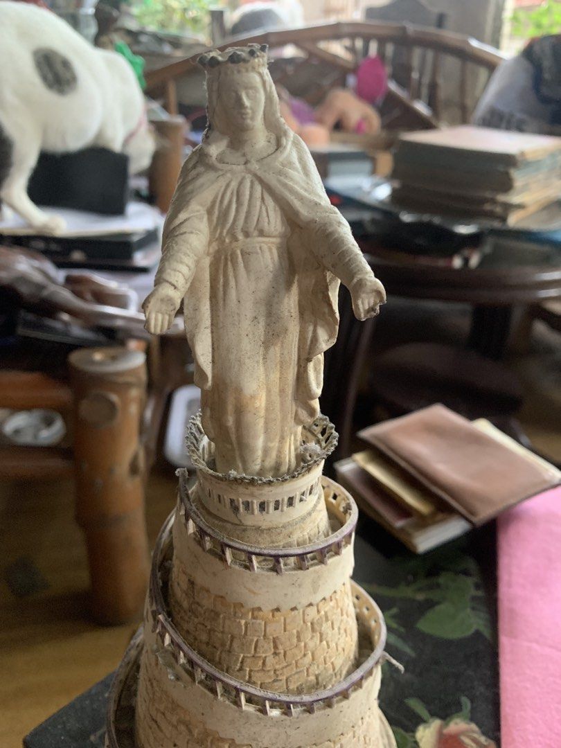 Religious Statue Figurine Mary Tower (Category: Religious Items) located in Quezon City. Submitted by sojisup (Listing ID 1465489825, Image 2). Description: - Elegant statue of Mary standing on a detailed spiral stone tower - Cream and beige color scheme with textured stonework and ramp railings - Features intricate details including a crown and flowing robes - Compact size, ideal for desk or shelf collections - Note: Minor dust and dirt in crevi