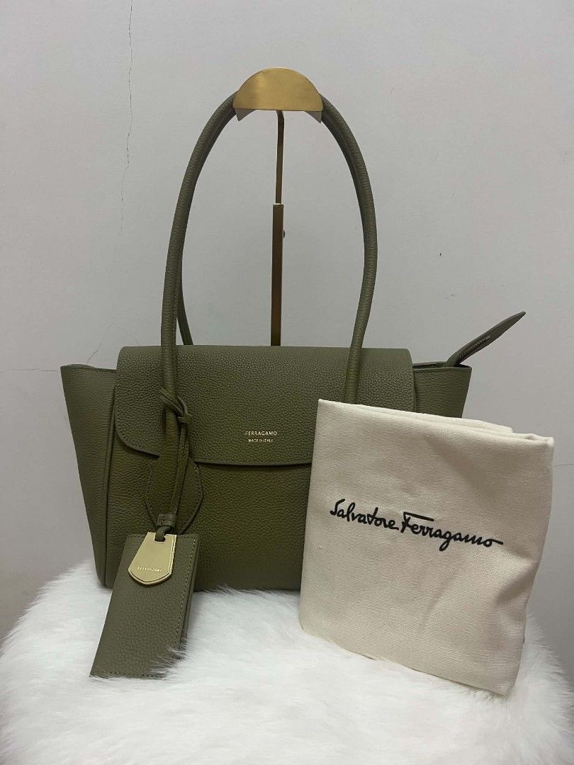 Salvatore Ferragamo Shoulder Bag (Category: Luxury Bags & Wallets) located in Paoay. Submitted by rvf1230 (Listing ID 1465390276, Image 2). Description: - Brand: Salvatore Ferragamo - Style: Tote bag in muted olive green textured/pebbled leather - Hardware: Elegant gold-tone lettering on the front flap - Straps: Comfortable dual shoulder straps - Extras: Matching luggage tag with metal detail included - Compartments: Convenient zipper closure poc