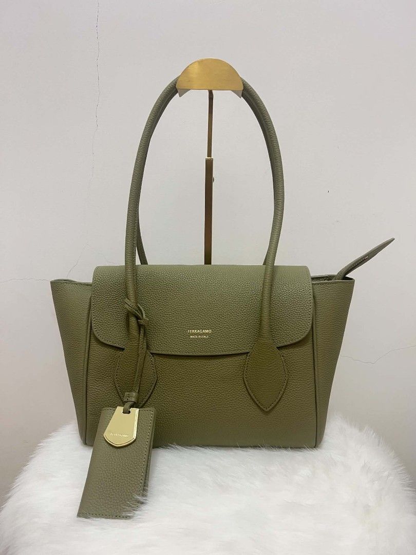 Salvatore Ferragamo Shoulder Bag (Category: Luxury Bags & Wallets) located in Paoay. Submitted by rvf1230 (Listing ID 1465390276, Image 1). Description: - Brand: Salvatore Ferragamo - Style: Tote bag in muted olive green textured/pebbled leather - Hardware: Elegant gold-tone lettering on the front flap - Straps: Comfortable dual shoulder straps - Extras: Matching luggage tag with metal detail included - Compartments: Convenient zipper closure poc