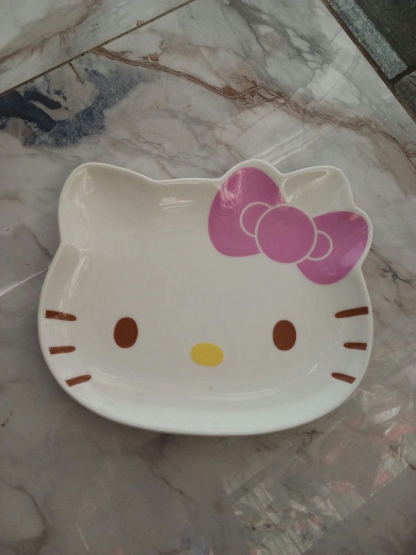 Sanrio Hello Kitty Face Ceramic Plate 1976 2009 (Category: Dinnerware & Cutlery) located in Davao. Submitted by mengsmixitems (Listing ID 1465423636, Image 1). Description: - Authentic Sanrio Kitty shaped ceramic plate - Features iconic white base, pink bow, and yellow nose - Official Sanrio stamp on bottom (dated 1976, 2009) - Raised edges, ideal for snacks or small dishes - Pristine condition: clean, zero chips, and no cracks - Must-have collec