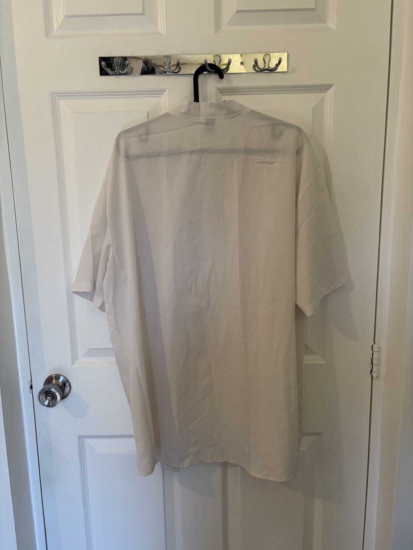 SHEIN White Button-Up Short Sleeve Shirt (Category: Tshirts & Polo Shirts ) located in Marikina City. Submitted by pong15 (Listing ID 1465500942, Image 2). Description: - Brand: SHEIN - Size: XL - Color: White with contrasting black buttons - Fit: Relaxed fit - Neckline: Collarless V-neck - Style: Short sleeve button-up - Condition: Great casual basic for everyday wear.