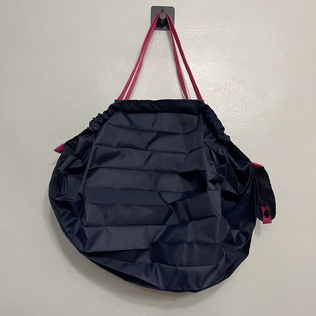 Shupatto Foldable Eco Shopping Bag Navy Pink - Medium (Category: Tote Bags) located in General Trias. Submitted by abellu (Listing ID 1465406859, Image 2). Description: - Brand: Shupatto - Color: Dark blue with pink handles - Design: Compact roll-up design secured with a snap button tab - Feature: Instantly expands when pulled from both ends for quick and easy use - Usage: Perfect for daily errands, grocery shopping, and travel - Eco-friendly and