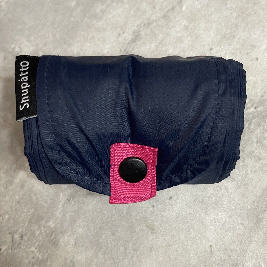 Shupatto Foldable Eco Shopping Bag Navy Pink - Medium (Category: Tote Bags) located in General Trias. Submitted by abellu (Listing ID 1465406859, Image 1). Description: - Brand: Shupatto - Color: Dark blue with pink handles - Design: Compact roll-up design secured with a snap button tab - Feature: Instantly expands when pulled from both ends for quick and easy use - Usage: Perfect for daily errands, grocery shopping, and travel - Eco-friendly and