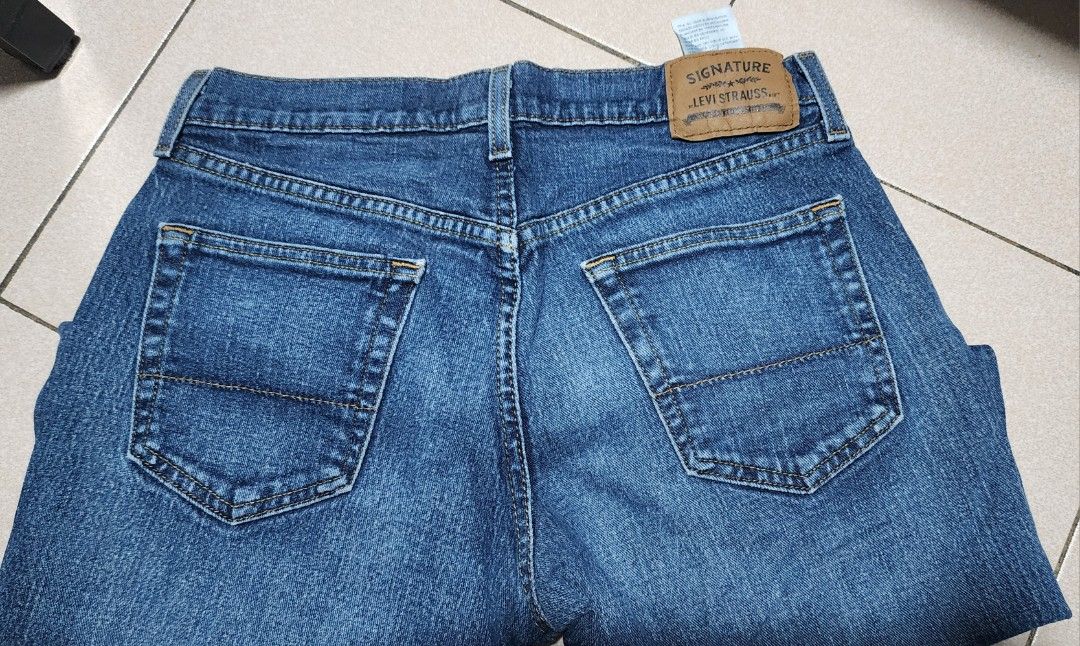 Signature Levi Strauss Relaxed Fit Jeans (Category: Jeans) located in Manila. Submitted by chichayako (Listing ID 1465450708, Image 3). Description: Signature Levi Strauss relaxed fit jeans in a medium blue wash. Classic five-pocket styling with standard button closure and zip fly. Leather patch on the back waistband. Material is a cotton blend with stretch. Straight legs, regular length. Interior care label lists machine wash instructions and fa