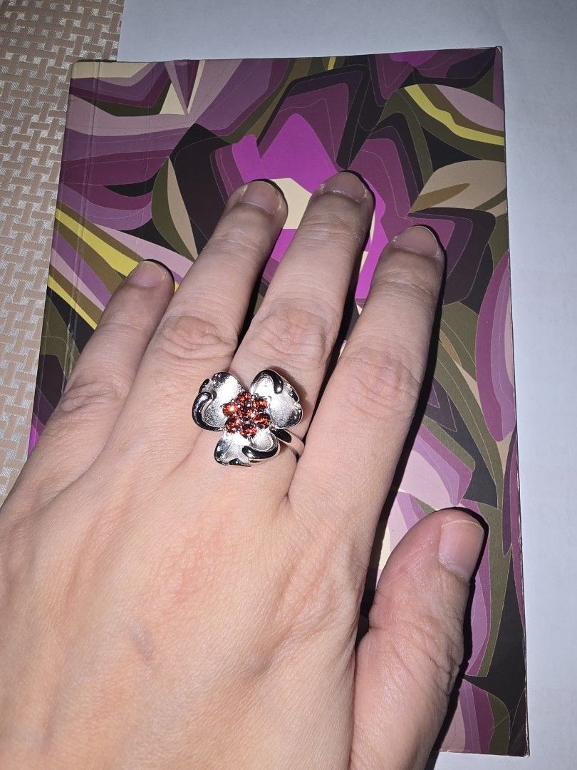 Silver Flower Ring with Garnet Gemstones (Category: Rings) located in Santa Rosa. Submitted by crystal1.0 (Listing ID 1465482194, Image 2). Description: - Design: Silver-tone ring shaped like a four-leaf clover or flower - Centerpiece: Cluster of deep red round gemstones - Finish: Brushed metal finish on petals with a slim band - Versatility: Pretty statement piece suitable for everyday wear or special occasions.