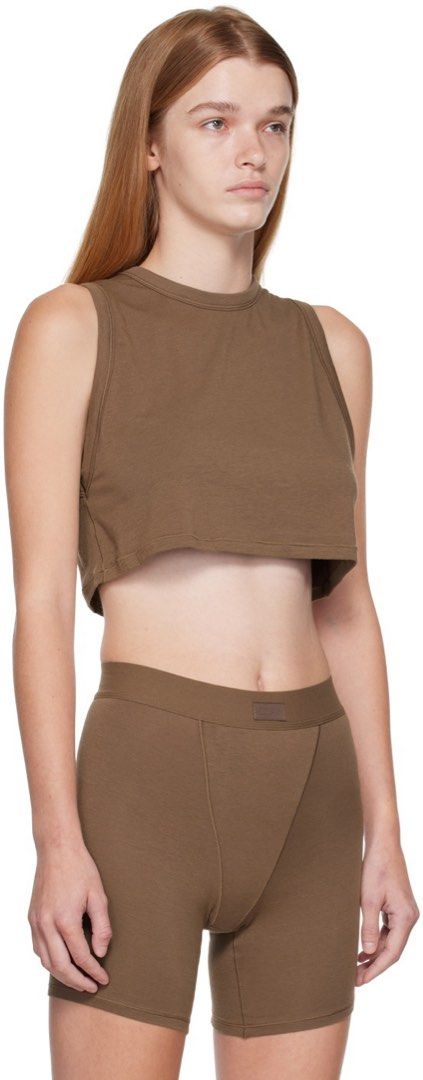 Skims Brown Crop Tank Top S (Category: Sleeveless) located in Rosales. Submitted by dariang22 (Listing ID 1465395851, Image 1). Description: - Color: Brown - Material: Soft, stretchy cotton -fit up to medium - Fit: Cropped tank top - Style: Simple, versatile basic for warm weather or layering - Condition: Worn a few times, washed and stored properly.
