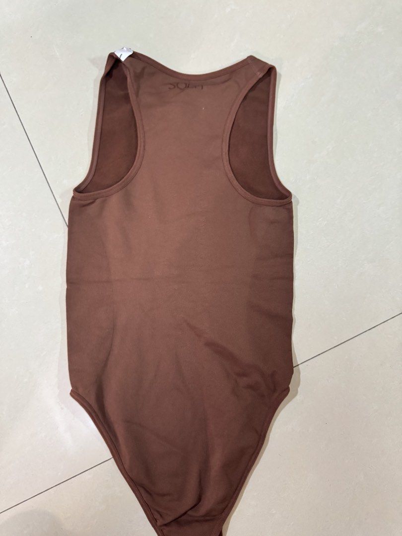 Sola body Hugging Brown Bodysuit (Category: Sleeveless) located in Quezon City. Submitted by sweetlyluxe (Listing ID 1465496546, Image 3). Description: - Brand: Sola Body Hugging collection - Color: Brown - Size: Small - Style: Crew neckline, sleeveless tank bodysuit - Material: Ribbed, stretchy fabric - Features: Bottom snap button closure, clean interior tags - Condition: Great pre-loved condition, used for photo only - Versatility: Perfect bas