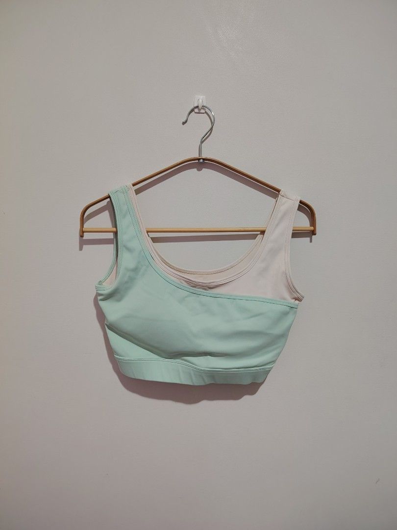 Sports Bra Mint Green (Category: Activewear) located in Mandaluyong City. Submitted by declutter_kween (Listing ID 1465526643, Image 2). Description: - Color: Pastel green and cream - Design: Asymmetric layered look with scoop neckline - Support: Wide underband and thick shoulder straps - Material: Stretchy athletic fabric - Best for: Workouts, yoga, and everyday athleisure wear - Size says XL but should fit M better.