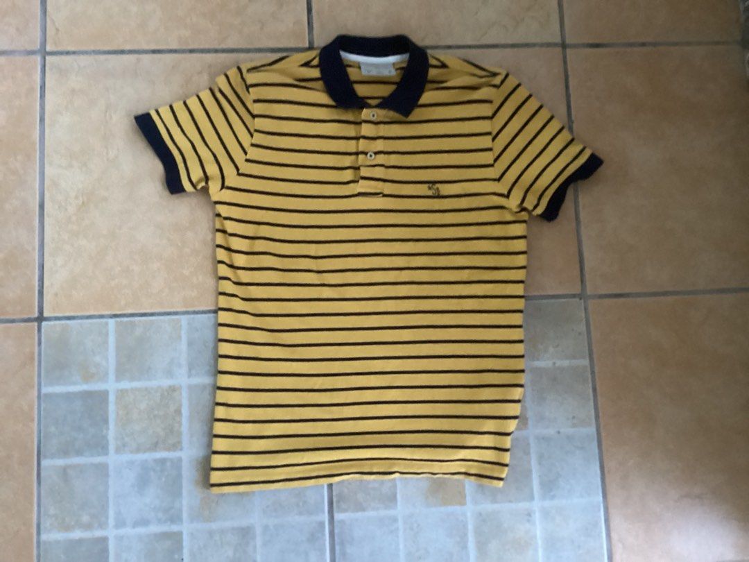 Springfield Striped Polo Shirt Size S (Category: Tshirts & Polo Shirts ) located in Manila. Submitted by jellythrift.ph (Listing ID 1465458586, Image 2). Description: - Brand: Springfield - Color: Yellow and dark blue stripes with contrast collar and cuffs - Size: S (EUR/UK S2, 170/92A) - Material: Comfortable cotton - Details: Two-button placket, small embroidered logo on chest - Condition: Clean and well-maintained, perfect for casual everyday 