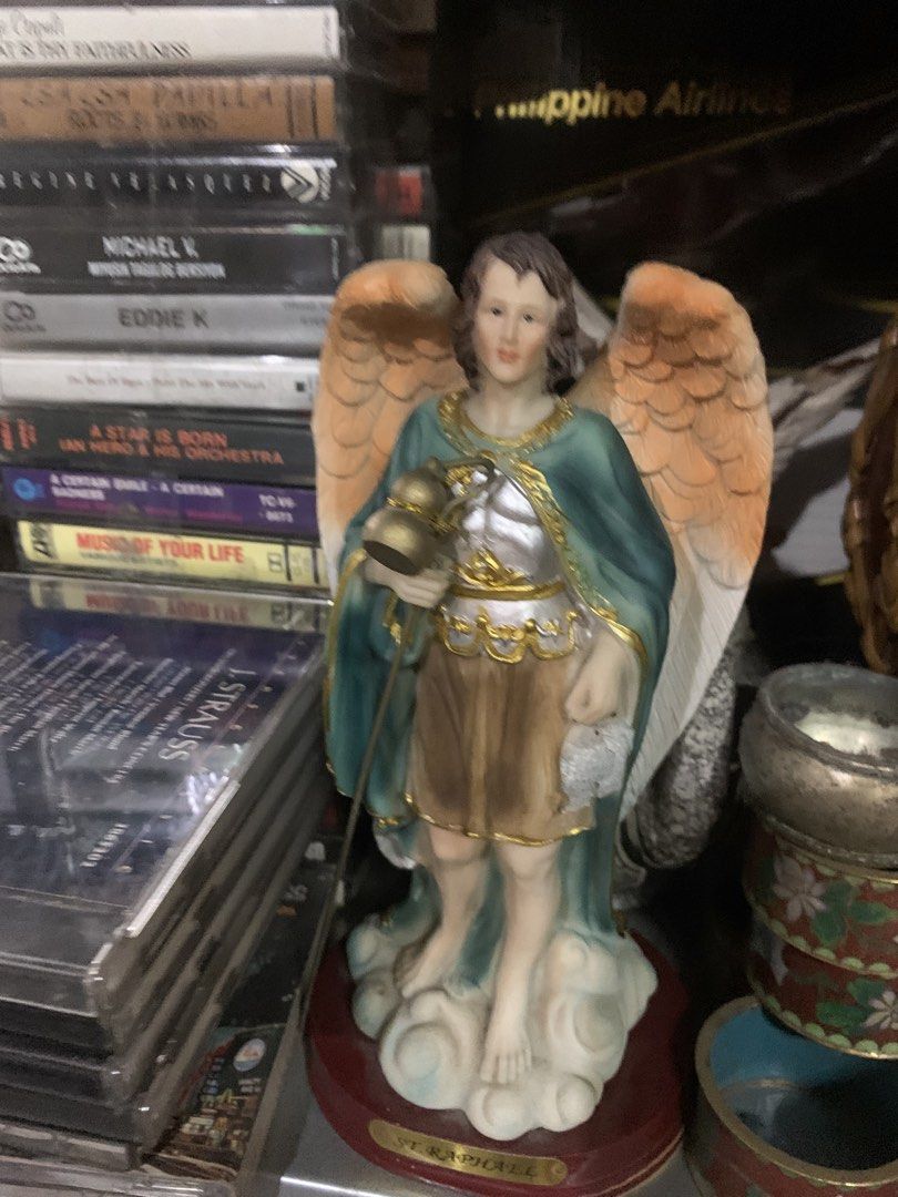 St. Raphael Archangel Resin Statue Figurine (Category: Figurines & Statues) located in Quezon City. Submitted by sojisup (Listing ID 1465489631, Image 2). Description: - Beautiful and detailed Saint Raphael the Archangel figurine - Features striking gold-tone armor, a teal cloak, and feathered wings - Holds his signature staff with a flask and a fish - Stands on a cloud base with a red platform and 'St. Raphael' name plate - Ideal for home altars
