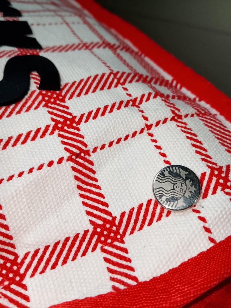 Starbucks Red Plaid Summer Carrier Bag (Category: Tote Bags) located in Santo Tomas. Submitted by noviemolde07815 (Listing ID 1465403989, Image 2). Description: - Authentic Starbucks summer collection carrier bag - Trendy red and white plaid pattern with bold black STARBUCKS lettering - Includes a detachable/attached metal Siren logo pin on the side - Vibrant bright orange interior lining complete with convenient pockets and official tag - Secure