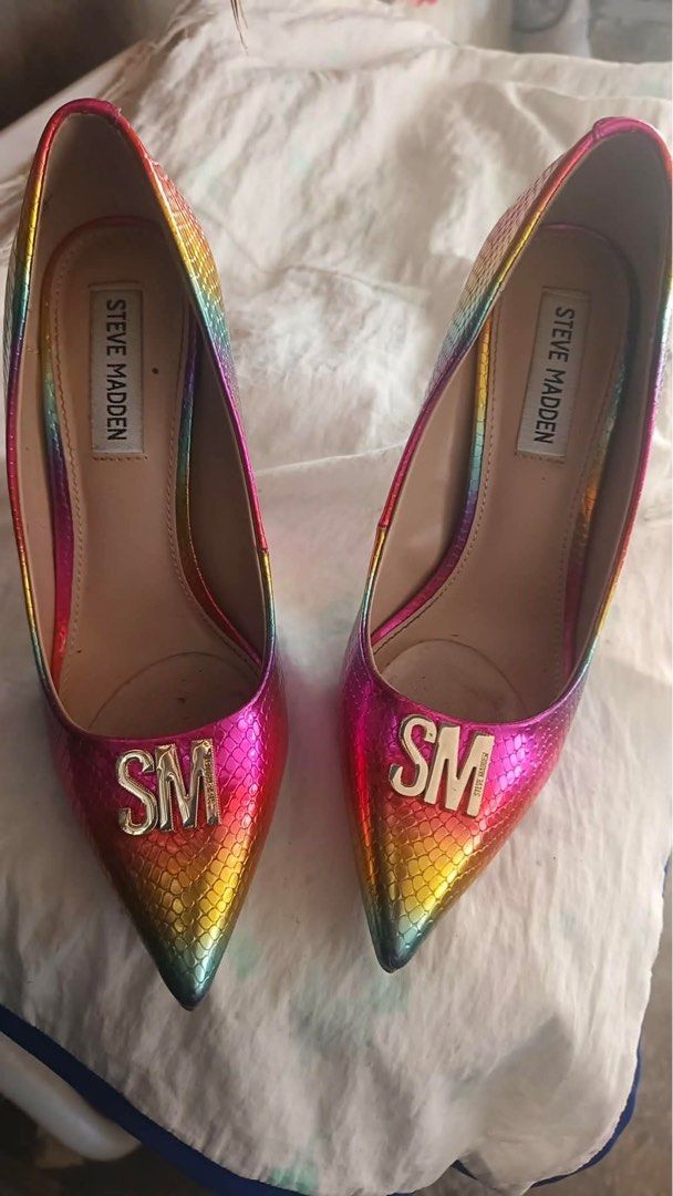 Steve Madden Rainbow Metallic Pointed Pumps with SM Logo (Category: Heels) located in Bulacan. Submitted by any.yna (Listing ID 1465387645, Image 1). Description: - Brand: Steve Madden - Style: Pointed toe slip-on stiletto heels - Design: Vibrant rainbow metallic snakeskin pattern - Details: Gold metal SM hardware on toe caps - Condition: Excellent pre-loved condition - Perfect for: Making a bold statement at parties or events -6.5 to 7 slim .