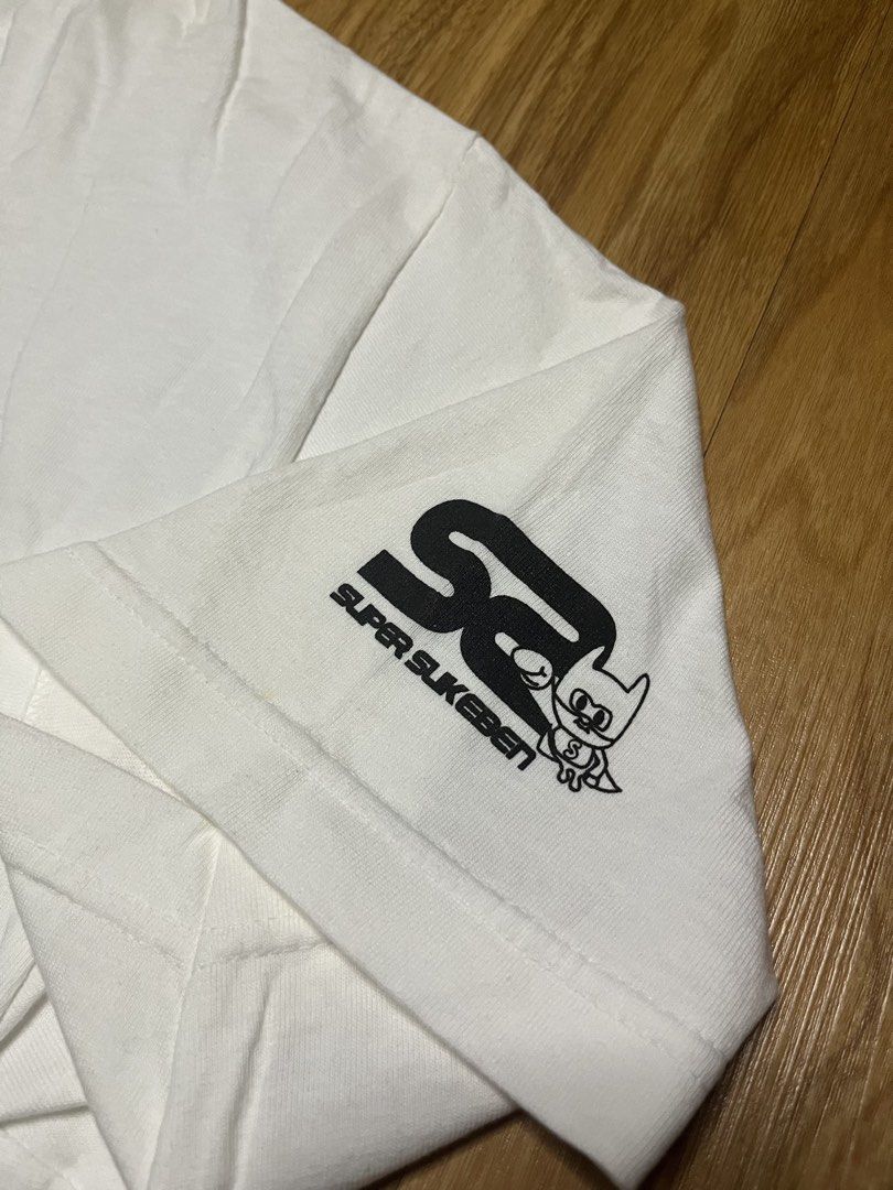 Super Sukeben Jail L •21.5x31 (Category: Tshirts & Polo Shirts ) located in Cebu City. Submitted by guttathreads (Listing ID 1465429794, Image 3). Description: - Brand: Super Sukeben - Color: Clean White - Size: Large (printed tag inside collar) - Material: 100% Cotton, Made in U.S.A. - Design: Large 'Sukeben Jail 324' mugshot graphic on the front - Detail: Small logo print on the left sleeve - Condition: Great quality with solid, un-fADEd prints