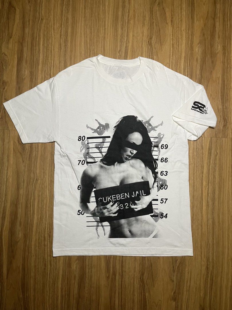 Super Sukeben Jail L •21.5x31 (Category: Tshirts & Polo Shirts ) located in Cebu City. Submitted by guttathreads (Listing ID 1465429794, Image 1). Description: - Brand: Super Sukeben - Color: Clean White - Size: Large (printed tag inside collar) - Material: 100% Cotton, Made in U.S.A. - Design: Large 'Sukeben Jail 324' mugshot graphic on the front - Detail: Small logo print on the left sleeve - Condition: Great quality with solid, un-fADEd prints